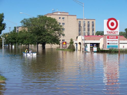 A flooded street with a Target store and a boat navigating through the water, showcasing significant flooding.