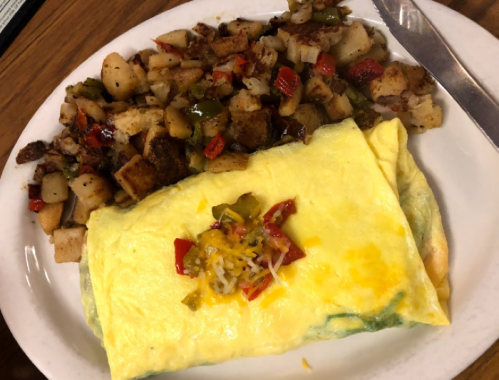 A plate featuring a cheese omelet with diced peppers and a side of seasoned hash browns.