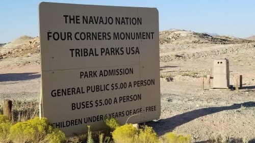 Sign for the Navajo Nation Four Corners Monument, detailing park admission fees and visitor information.