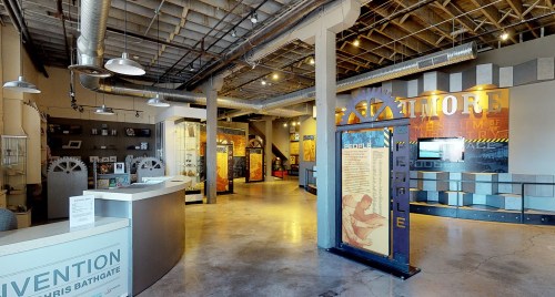 Interior view of a modern exhibition space featuring displays, informational panels, and an open layout.
