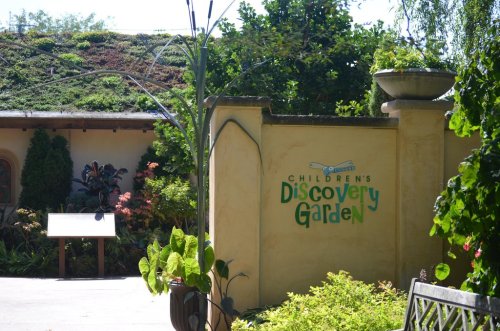 Entrance to the Children's Discovery Garden, featuring lush greenery and a welcoming sign.