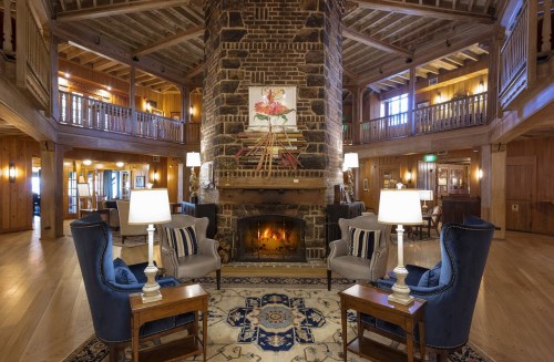 Cozy lodge interior featuring a stone fireplace, comfortable seating, and warm wooden accents.