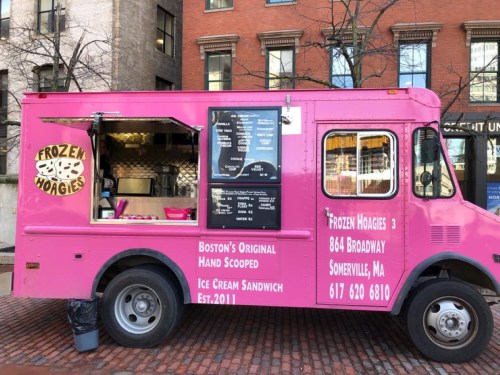 A pink food truck named "Frozen Hoagies" offers ice cream sandwiches in Boston, with a menu displayed on the side.