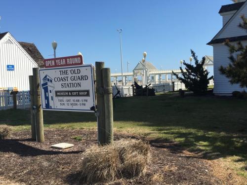Sign for the Old Coast Guard Station, with a museum and gift shop, set against a clear blue sky.