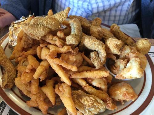 A plate filled with various fried foods, including fish, shrimp, and crispy batter-fried items.