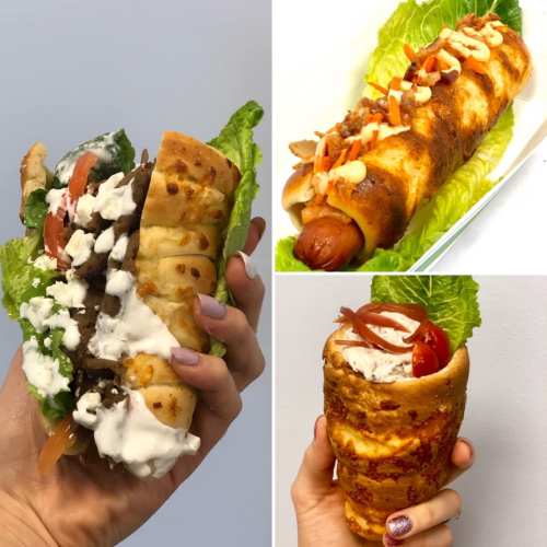 A hand holding a loaded sandwich with lettuce, tomatoes, and sauce, alongside two other unique food creations.