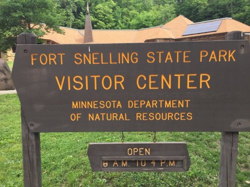 Sign for Fort Snelling State Park Visitor Center, listing hours and Minnesota Department of Natural Resources. Open 8 AM to 4 PM.