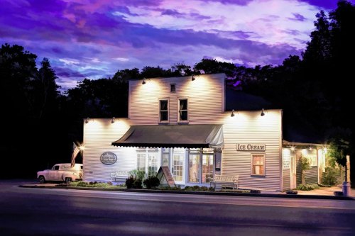 A charming ice cream shop at dusk, with a vintage car parked outside and a colorful sky in the background.