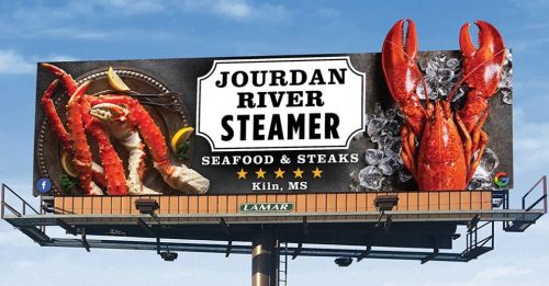 Billboard for Jourdan River Steamer featuring seafood, including crab and lobster, located in Kiln, MS.