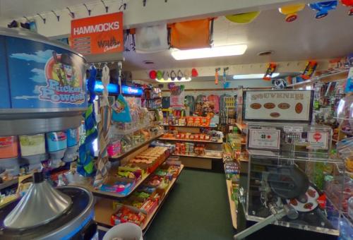 A colorful store interior filled with snacks, souvenirs, and various merchandise, including hammocks and toys.