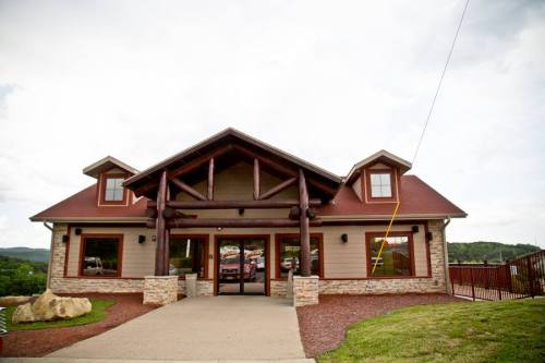 A large, rustic building with a log cabin design, featuring a stone facade and a welcoming entrance.