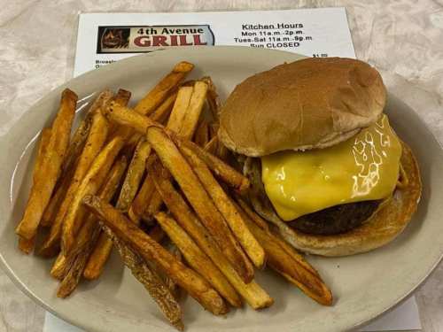 A plate with a cheeseburger and golden fries, next to a menu for 4th Avenue Grill.