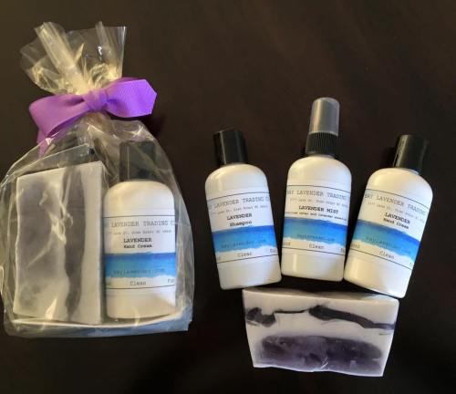 A gift set featuring lavender products: hand cream, shampoo, and body mist, alongside two lavender soaps.