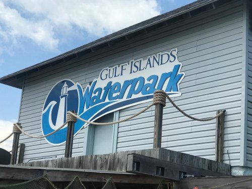 Sign for Gulf Islands Waterpark on a wooden building with a blue sky in the background.