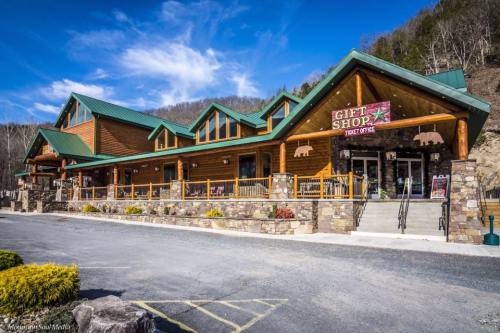 A rustic gift shop and ticket office with a wooden facade, surrounded by mountains and a clear blue sky.