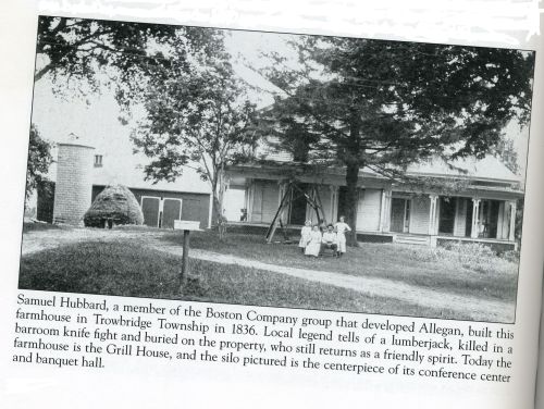 Historic farmhouse in Allegan, built in 1836, with a group of people and a silo in the background.
