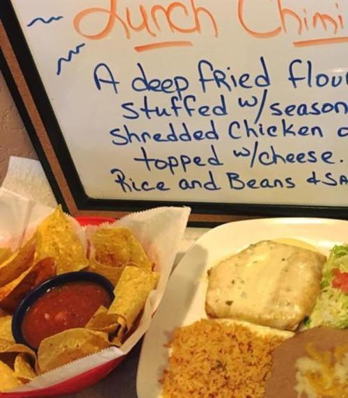 A plate of lunch chimichangas with rice, beans, and tortilla chips with salsa on the side.