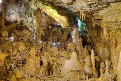 A cavernous underground cave with rock formations, stalactites, and illuminated pathways.