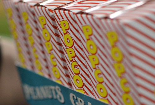 A row of striped popcorn boxes with bright yellow lettering on a blue background.