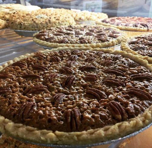 A display of freshly baked pecan pies in a bakery, showcasing their golden crust and nutty topping.