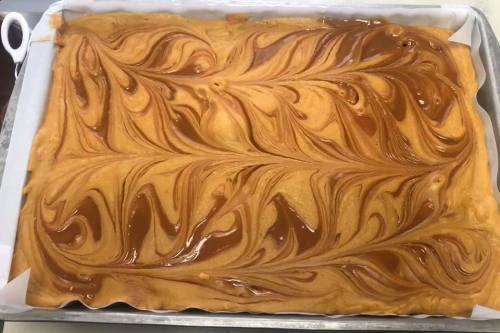 A tray of swirled caramel and pumpkin dessert, featuring intricate patterns of golden and brown hues.