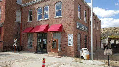 Exterior of a brick museum building with red awnings, large windows, and a sign reading "MUSEUM."