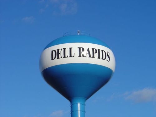 A blue water tower with the words "DELL RAPIDS" prominently displayed against a clear blue sky.