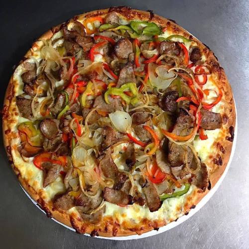 A freshly baked pizza topped with sliced onions, bell peppers, and seasoned meat on a golden crust.