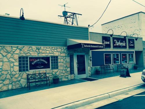 Exterior of a restaurant with a stone facade, large windows, and an "OPEN" sign displayed.