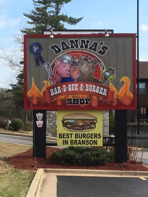 Sign for Danna's Bar-B-Que & Burger Shop in Branson, featuring cartoon pigs and a banner for "Best Burgers."