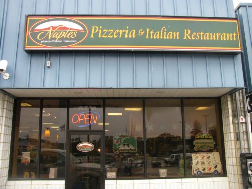 Sign for Naples Pizzeria & Italian Restaurant, featuring "OPEN" in the window and a menu display outside.