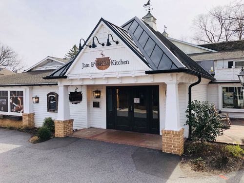 Exterior of Jam & Relish Kitchen, featuring a white building with a black roof and welcoming entrance.