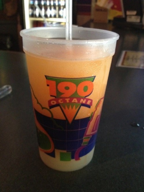 A colorful cup labeled "190 Octane" filled with a vibrant orange drink and a straw.