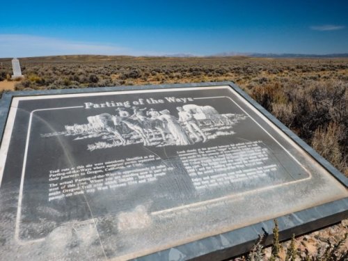 A historical plaque titled "Parting of the Ways" in a desert landscape, with mountains in the background.