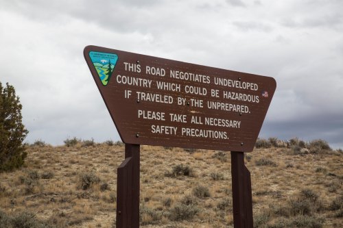Sign warning about hazards in undeveloped country, advising travelers to take necessary safety precautions.