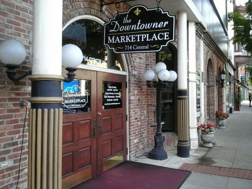 Entrance to the Downtowner Marketplace, featuring brick walls, decorative lamps, and a sign above the door.