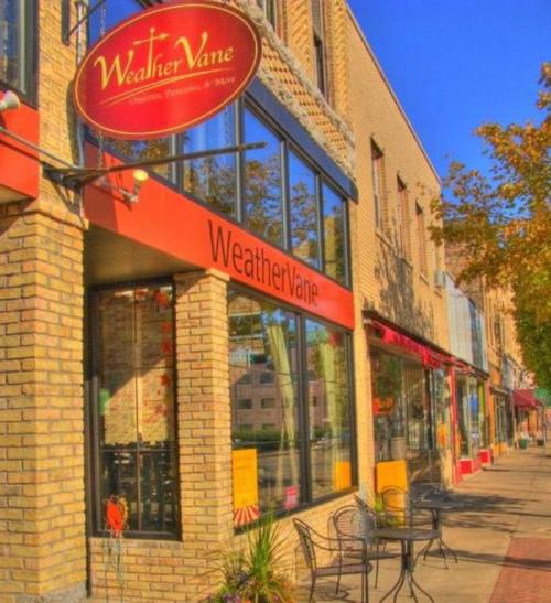 Exterior view of the Weather Vane restaurant, featuring a brick facade and outdoor seating on a sunny day.
