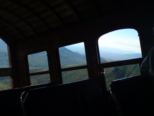 View from inside a train car, showcasing mountains and valleys through large windows.