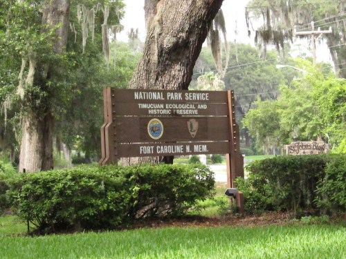 Sign for the Timucuan Ecological and Historic Preserve, Fort Caroline Memorial, surrounded by greenery.