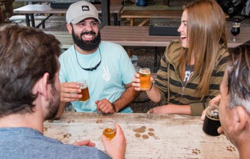 A group of friends enjoying drinks at a table, laughing and sharing a fun moment together.