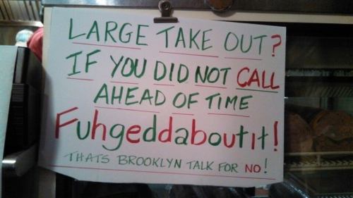 Sign reading: "Large take out? If you did not call ahead, Fuhgeddaboudit! That's Brooklyn talk for NO!"