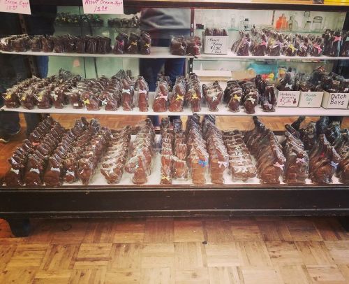 A display case filled with various chocolate treats, neatly arranged in bags with colorful tags.