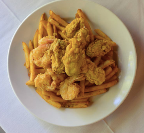 A plate of golden fried shrimp and crispy French fries.