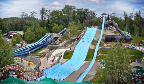 A vibrant water park featuring multiple water slides and visitors enjoying the attractions on a sunny day.