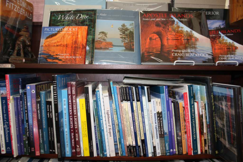 A bookshelf filled with various books, including titles about Apostle Islands and Pictured Rocks.