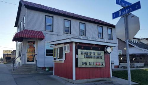 A small restaurant with a red and white awning, featuring a sign that says "Open Daily" on a street corner.