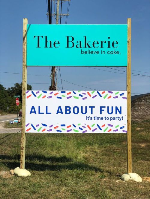 A sign for "The Bakerie" with the slogan "believe in cake" and a banner reading "ALL ABOUT FUN, it's time to party!"