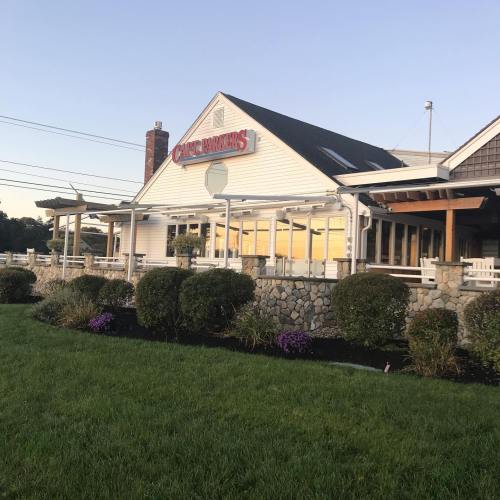 Exterior of a restaurant named "Cape Parkers," featuring a stone facade and landscaped greenery in front.
