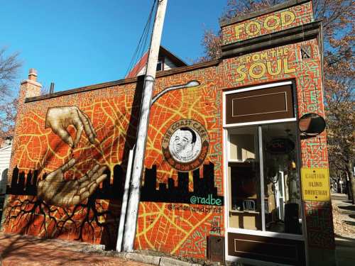 Colorful mural on a building featuring hands reaching out, with the text "Food from the Soul" and a city skyline.