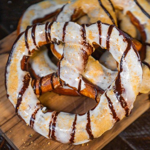 A close-up of a large pretzel drizzled with chocolate and white icing, sprinkled with graham cracker crumbs.